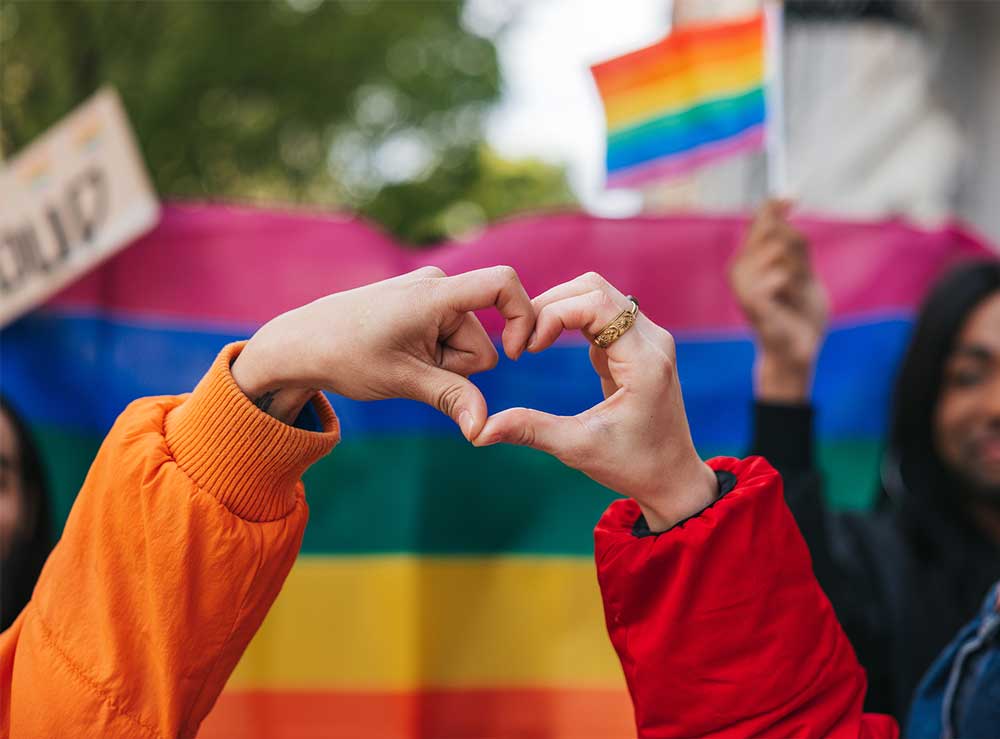 Hands make a heart to show solidarity at a Pride event